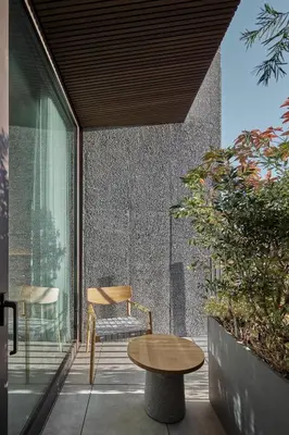 a patio with a wooden table and a chair at TRUNK(HOTEL) YOYOGI PARK in Tokyo