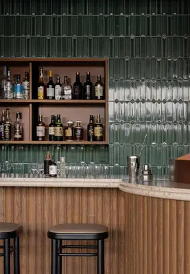 a bar with two stools and bottles of alcohol at TRUNK(HOTEL) YOYOGI PARK in Tokyo