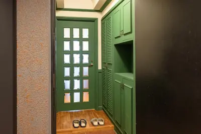 a green door with two pairs of shoes in a room at \u30b5\u30f3\u30e2\u30fc\u30eb\u7b2c\u4e09\u30de\u30f3\u30b7\u30e7\u30f3 in Tokyo
