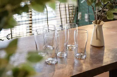 a group of glasses sitting on a table with a vase at \u30b5\u30f3\u30e2\u30fc\u30eb\u7b2c\u4e09\u30de\u30f3\u30b7\u30e7\u30f3 in Tokyo