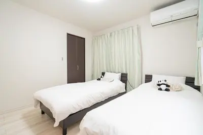 a bedroom with two beds and a window at 3 BR house 7 mins on foot from Otsuka on the Yamanote Line in Tokyo