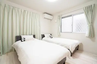 two beds in a room with a window at 3 BR house 7 mins on foot from Otsuka on the Yamanote Line in Tokyo