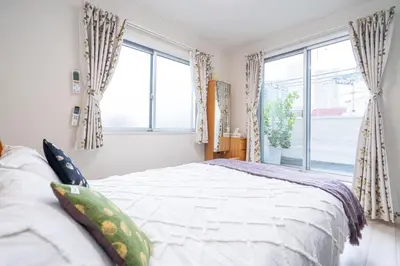 a bedroom with a bed and large windows at 3 BR house 7 mins on foot from Otsuka on the Yamanote Line in Tokyo