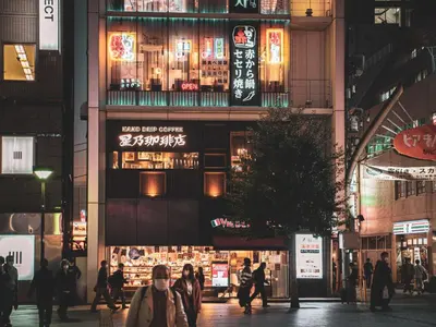 a group of people walking down a city street at night at 1F Facing Skdytree 6min stn Direct NRT&HND&Disney in Tokyo
