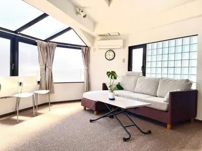a living room with a couch and a table at \u6c60\u888b\u4e09\u99c5\u306e\u5bb6 \u5927\u5c71\u99c5\u304b\u3089\u5f92\u6b694\u5206 in Tokyo