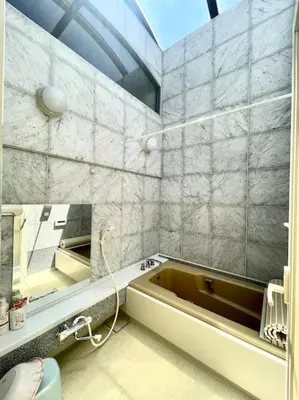 a bathroom with a bath tub and a mirror at \u6c60\u888b\u4e09\u99c5\u306e\u5bb6 \u5927\u5c71\u99c5\u304b\u3089\u5f92\u6b694\u5206 in Tokyo