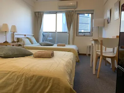 a hotel room with two beds and a window at Studio in the center of Shibuya \u6e0b\u8c37\u9053\u7384\u5742 in Tokyo