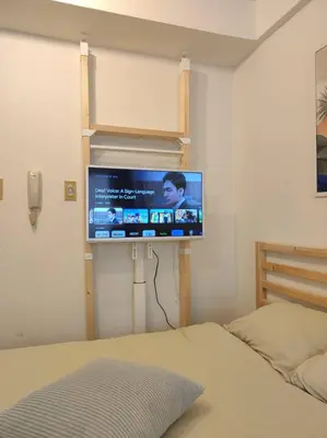 a bedroom with a flat screen tv on the wall at Studio in the center of Shibuya \u6e0b\u8c37\u9053\u7384\u5742 in Tokyo