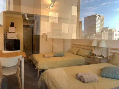 a hotel room with two beds and a tv at Studio in the center of Shibuya \u6e0b\u8c37\u9053\u7384\u5742 in Tokyo