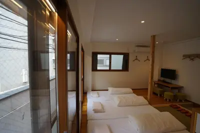 a bedroom with two beds and a television in it at da Haus Ikebukuro in Tokyo