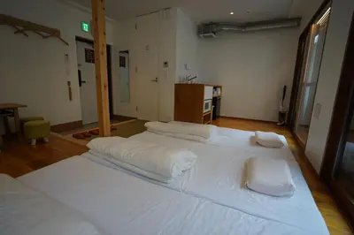 a large white bed with three pillows on top of it at da Haus Ikebukuro in Tokyo