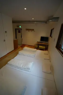 a room with three beds in the middle of it at da Haus Ikebukuro in Tokyo