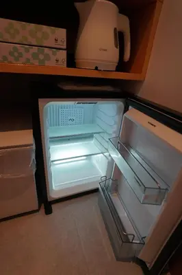 an empty refrigerator with its door open in a kitchen at da Haus Ikebukuro in Tokyo