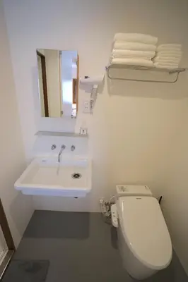 a white bathroom with a toilet and a sink at da Haus Ikebukuro in Tokyo