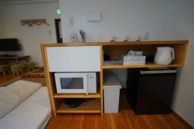a kitchen with a microwave on a shelf with a counter at da Haus Ikebukuro in Tokyo