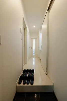 a hallway with a row of black chairs on the floor at Setagaya House by Tranova in Tokyo