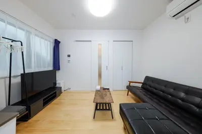 a living room with a black couch and a table at Setagaya House by Tranova in Tokyo