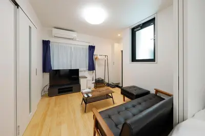 a living room with a couch and a television at Setagaya House by Tranova in Tokyo