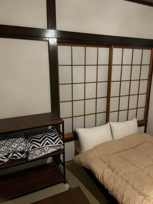 a room with a bed and a pillow next to at 1970's Japanese style dorm house in Tokyo