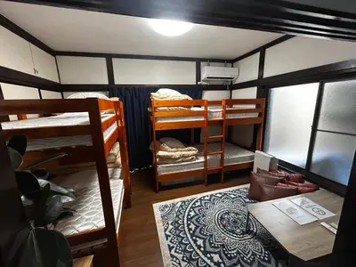 a room with two bunk beds and a table at 1970's Japanese style dorm house in Tokyo