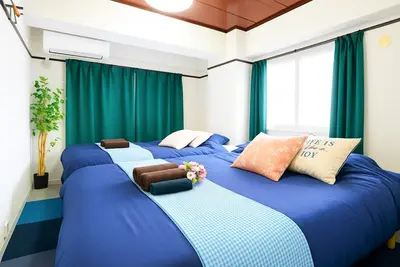 two large beds in a room with green curtains at Ryogoku 601 Private Cozy Stay 4min Walk Station Asakusa Nearby in Tokyo