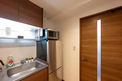a kitchen with a stainless steel refrigerator and a sink at LUANAHOTEL IN SINNAKANO in Tokyo