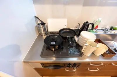 a kitchen stove with a pot on it next to a sink at LUANAHOTEL IN SINNAKANO in Tokyo