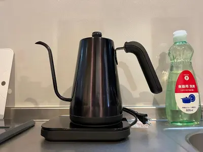 a black kettle on a counter next to a bottle of water at LUANAHOTEL IN SINNAKANO in Tokyo