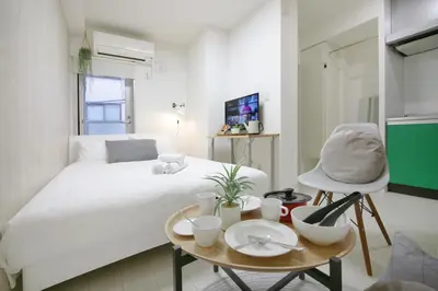 a bedroom with a bed and a table and a chair at Real Kinshi 201 in Tokyo