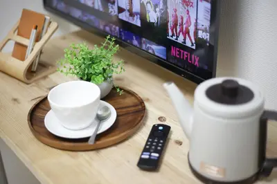 a table with a coffee cup and a remote control at Real Kinshi 201 in Tokyo