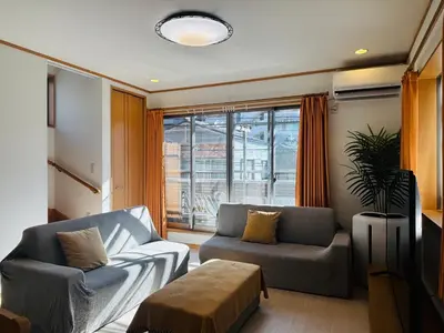 a living room with two couches and a large window at Kamei House in Tokyo