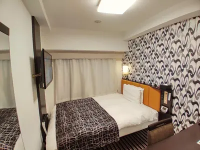 a small bedroom with a bed and a wall at APA Hotel Nagatacho Hanzomon Ekimae in Tokyo