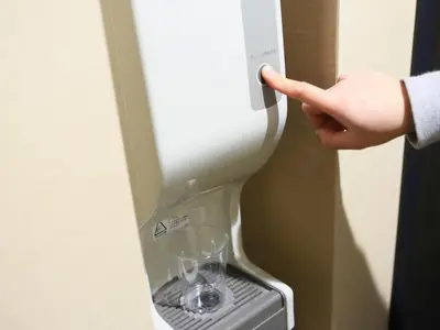 a person pointing at a wine glass in a machine at APA Hotel Nagatacho Hanzomon Ekimae in Tokyo