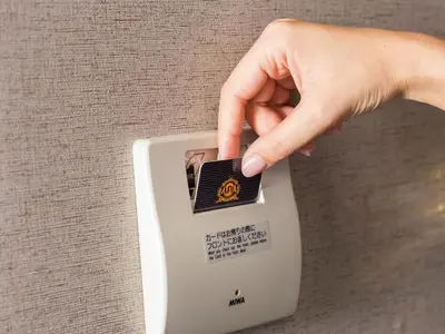 a hand is turning on a light switch at APA Hotel Nagatacho Hanzomon Ekimae in Tokyo