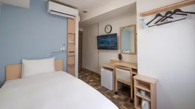 a bedroom with a bed and a desk and a mirror at Toyoko Inn Kayabacho Eki in Tokyo