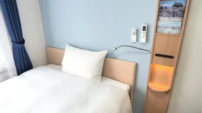 a small bedroom with a bed and a lamp at Toyoko Inn Kayabacho Eki in Tokyo