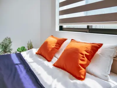 a bed with two orange pillows on top of it at 2023 Open Shinjuku Okubo 5mins to 2stns 200M WIFI in Tokyo