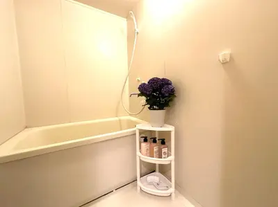 a bathroom with a mirror and a vase with purple flowers at shibuya center -Max 5p-\u5bb6\u5ead\u516c\u5bd3-\u8f66\u7ad97\u5206-\u76f4\u8fbe\u65b0\u5bbf\u6d89\u8c37\u516d\u672c\u6728\u94f6\u5ea7 in Tokyo