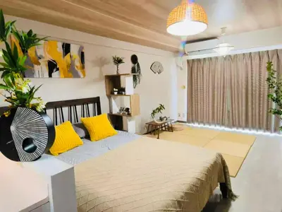 a bedroom with a bed with yellow pillows and a fan at shibuya center -Max 5p-\u5bb6\u5ead\u516c\u5bd3-\u8f66\u7ad97\u5206-\u76f4\u8fbe\u65b0\u5bbf\u6d89\u8c37\u516d\u672c\u6728\u94f6\u5ea7 in Tokyo