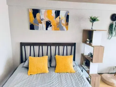 a bedroom with a bed with two yellow pillows at shibuya center -Max 5p-\u5bb6\u5ead\u516c\u5bd3-\u8f66\u7ad97\u5206-\u76f4\u8fbe\u65b0\u5bbf\u6d89\u8c37\u516d\u672c\u6728\u94f6\u5ea7 in Tokyo
