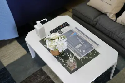 a white coffee table with a book and flowers on it at Kameari 1108 Budget Stay High Floor Near Station Mall Disney Access in Tokyo