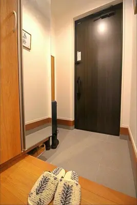 a room with a door and a table with shoes at Uhome Ikebukuro Villa 7 in Tokyo