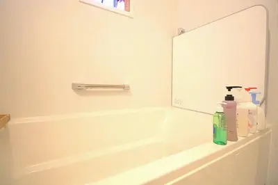 a bathroom with a bath tub and a mirror at Uhome Ikebukuro Villa 7 in Tokyo
