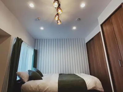 a bedroom with a bed and a chandelier at KUMOMA Entire Apartment Skytree \u8cb8\u5207 \u6574\u5957\u51fa\u79df Max4 People \u6700\u59274\u4eba 8min to sta \u8f66\u7ad9\u6b65\u884c8\u5206\u949f 36m2 in Tokyo