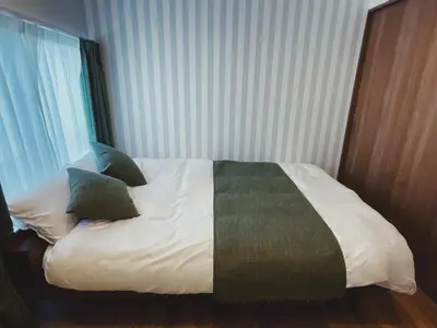 a bed with two pillows on it in a room at KUMOMA Entire Apartment Skytree \u8cb8\u5207 \u6574\u5957\u51fa\u79df Max4 People \u6700\u59274\u4eba 8min to sta \u8f66\u7ad9\u6b65\u884c8\u5206\u949f 36m2 in Tokyo
