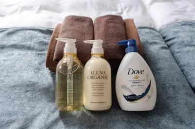 three bottles of cleaning products sitting on a bed at Granduo \u677e\u6fe4 in Tokyo