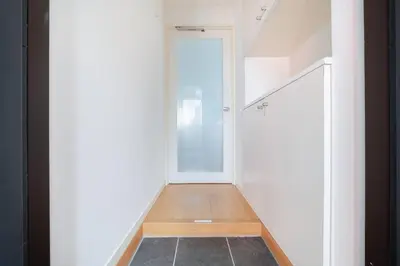 a hallway with white walls and a stair case at Granduo \u677e\u6fe4 in Tokyo