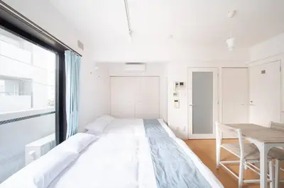 a large bed in a room with a table at Granduo \u677e\u6fe4 in Tokyo