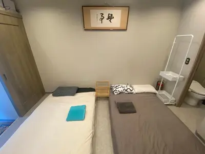 a small room with two beds and a toilet at 54Journey Roppongi in Tokyo