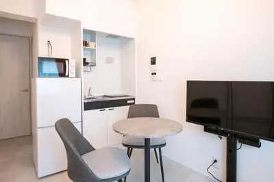a small room with a table and chairs and a kitchen at \u58a8\u7530Dias in Tokyo